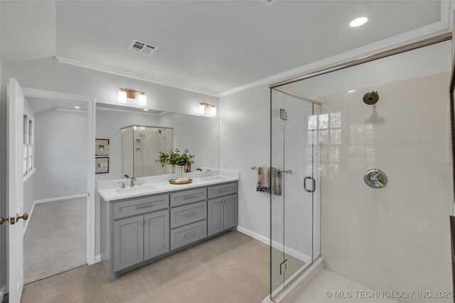 full bath featuring double vanity, visible vents, ornamental molding, a stall shower, and a sink