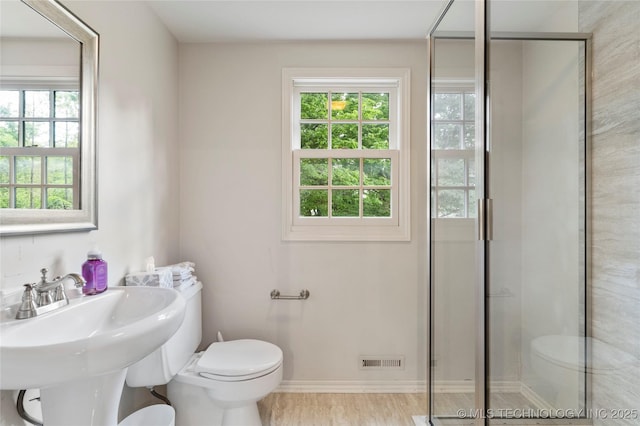 full bath featuring toilet, a stall shower, visible vents, and a sink