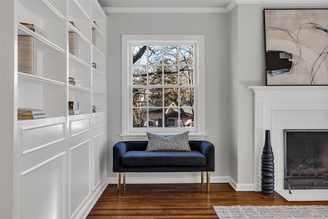 living area with ornamental molding, dark wood-style flooring, a fireplace, and baseboards