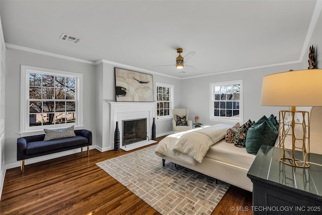 bedroom with a fireplace, visible vents, baseboards, dark wood finished floors, and crown molding