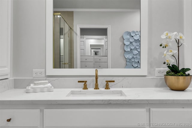 full bath featuring a shower stall, ornamental molding, and vanity