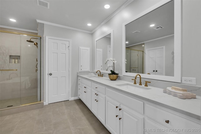 bathroom with a stall shower, crown molding, visible vents, and a sink