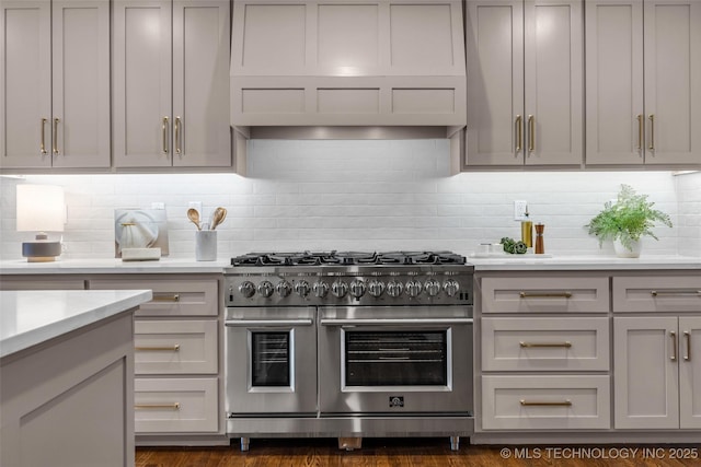 kitchen featuring light countertops, gray cabinets, double oven range, and decorative backsplash