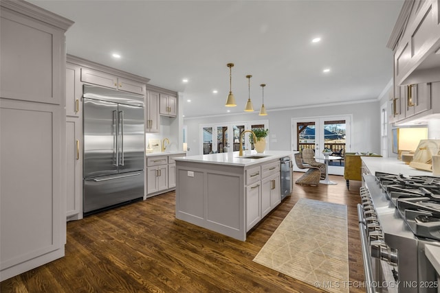 kitchen featuring french doors, high end appliances, light countertops, ornamental molding, and a sink