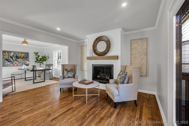 living area featuring a fireplace, recessed lighting, ornamental molding, wood finished floors, and baseboards