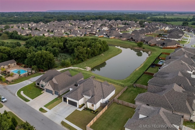 aerial view at dusk featuring a water view