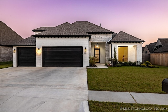 view of front of property featuring a garage and a lawn