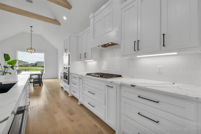 kitchen featuring stainless steel appliances, decorative light fixtures, light stone countertops, and white cabinets