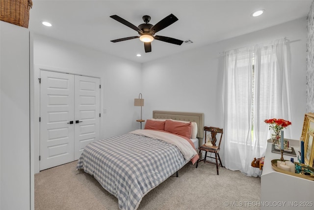 carpeted bedroom featuring ceiling fan and a closet