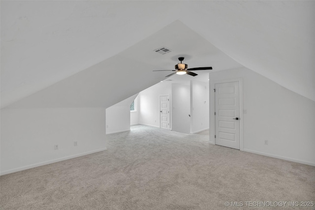 additional living space with ceiling fan, light colored carpet, and vaulted ceiling