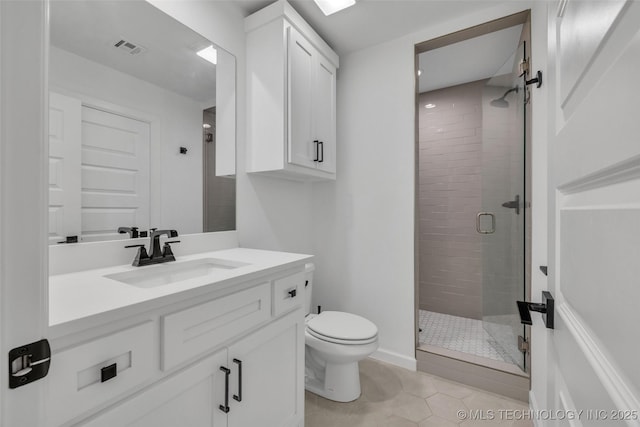 bathroom with toilet, vanity, tile patterned floors, and a shower with shower door