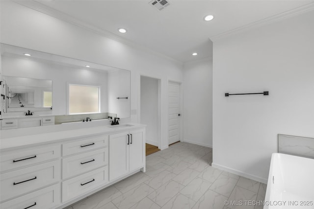 bathroom featuring vanity, crown molding, and a tub