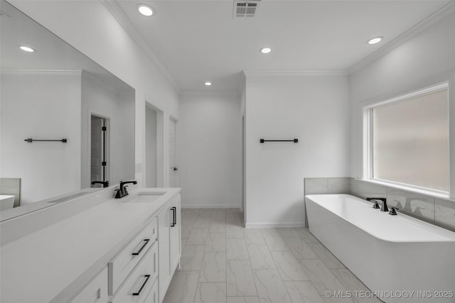 bathroom featuring crown molding, a bathing tub, and vanity