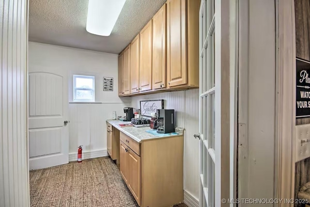 kitchen featuring light brown cabinets and a textured ceiling