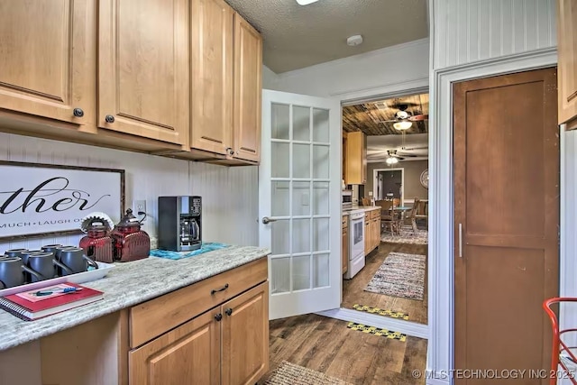 kitchen featuring white electric range, a textured ceiling, and hardwood / wood-style flooring