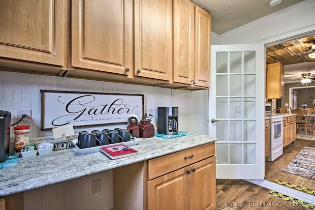 kitchen with white range with electric cooktop, dark hardwood / wood-style flooring, ceiling fan, light stone counters, and a textured ceiling