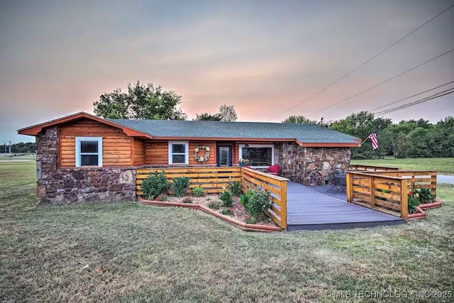 view of front of home with a wooden deck and a lawn