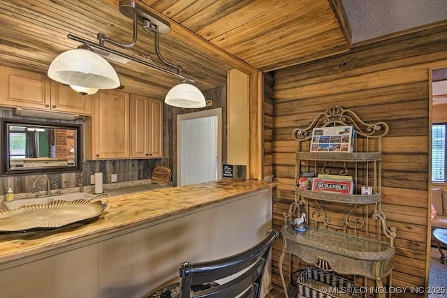 kitchen with wood counters, hanging light fixtures, wooden walls, and wooden ceiling