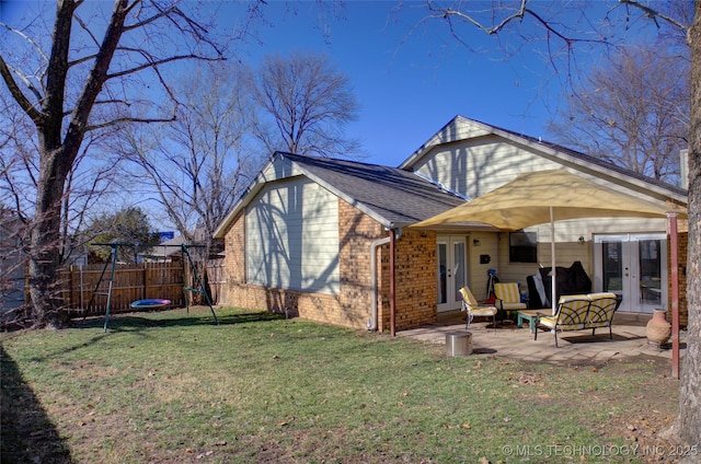 rear view of house with a yard, a patio area, and french doors