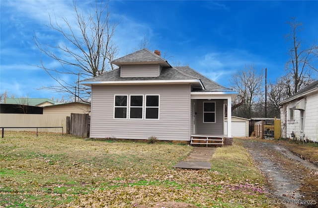 rear view of property featuring a garage and a yard