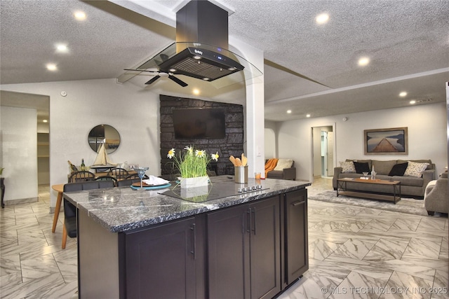 kitchen featuring ceiling fan, dark stone countertops, island range hood, a textured ceiling, and vaulted ceiling