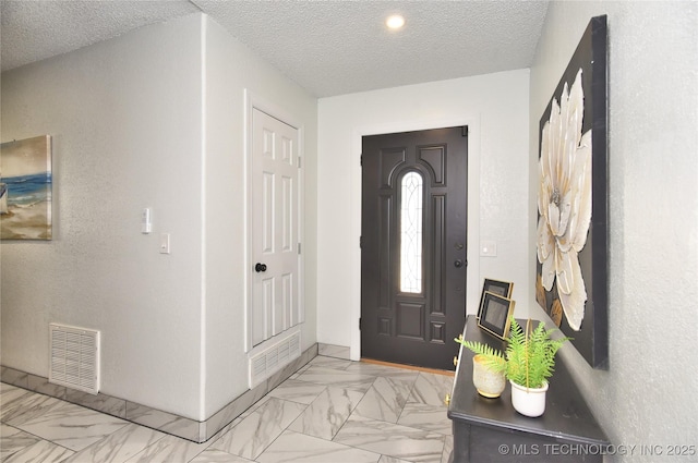 foyer with a textured ceiling