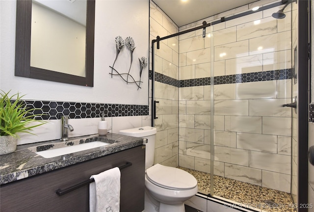 bathroom featuring vanity, an enclosed shower, and toilet