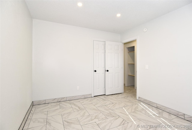 unfurnished bedroom featuring a closet and a textured ceiling