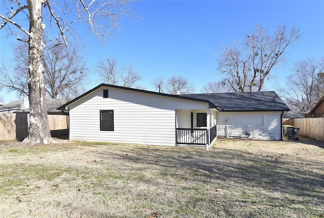 rear view of property featuring a yard and covered porch