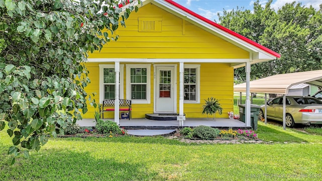 view of front of house with a porch, a carport, and a front lawn