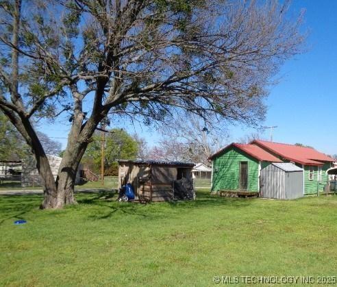 795 6th St, Wilson, OK 73463 - view of yard featuring a storage unit and an outdoor structure
