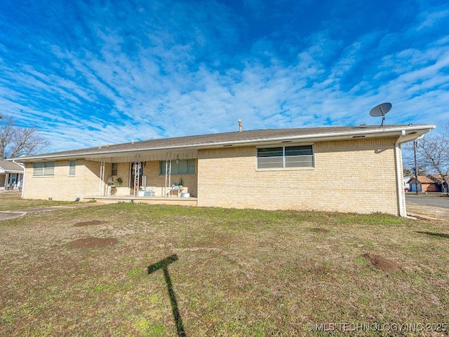 rear view of house with a patio and a lawn