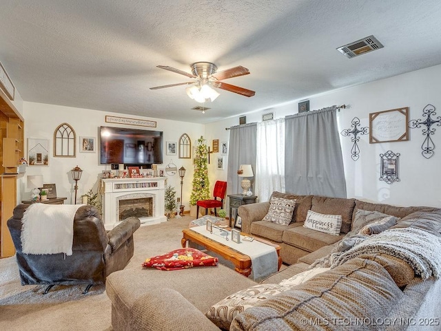 living room with ceiling fan, light carpet, and a textured ceiling