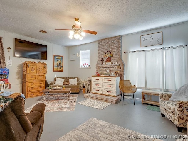 living area with ceiling fan, concrete floors, and a textured ceiling