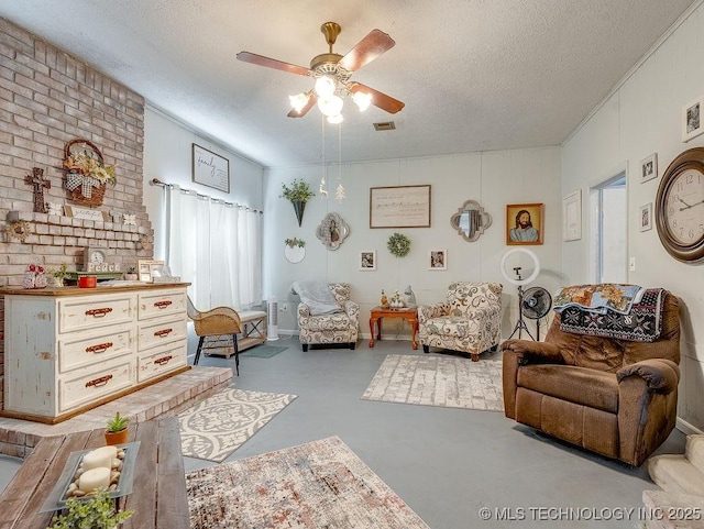 living area featuring ceiling fan and a textured ceiling