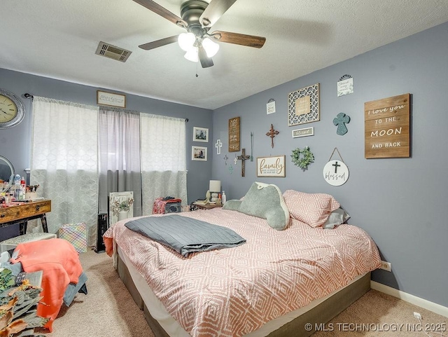 carpeted bedroom featuring ceiling fan and a textured ceiling