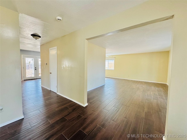 empty room with a textured ceiling and dark hardwood / wood-style flooring