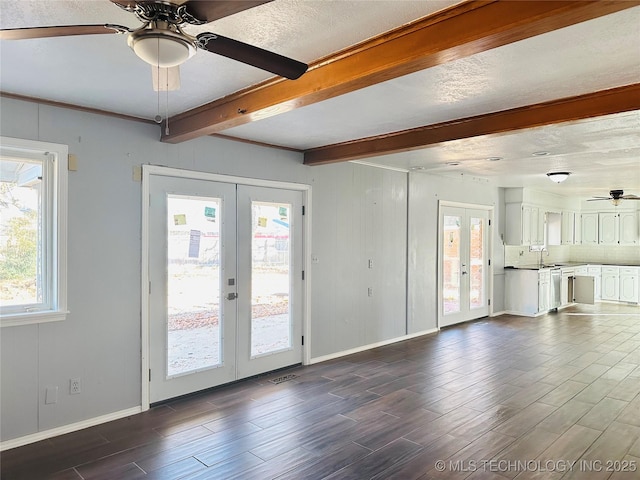 unfurnished living room featuring french doors, dark hardwood / wood-style floors, sink, and beamed ceiling