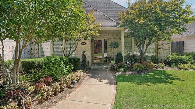 entrance to property featuring a lawn