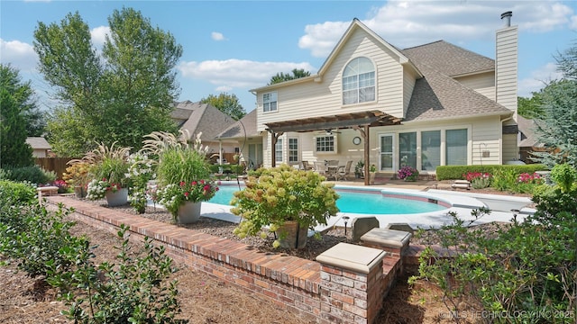 rear view of property featuring a fenced in pool, a patio, and a pergola