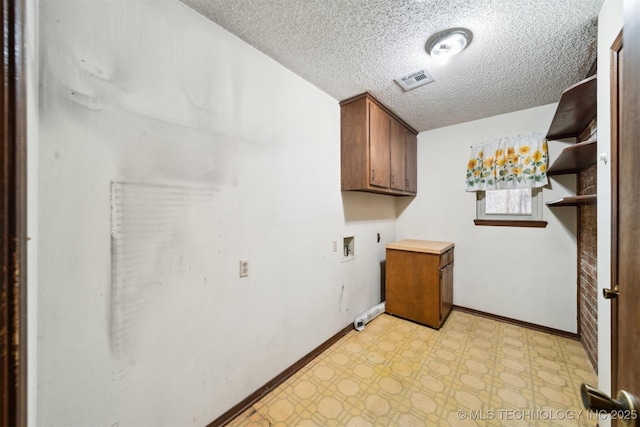 clothes washing area with electric dryer hookup, hookup for a washing machine, cabinets, and a textured ceiling