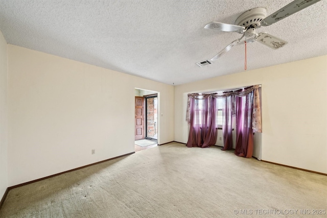 carpeted spare room featuring ceiling fan and a textured ceiling