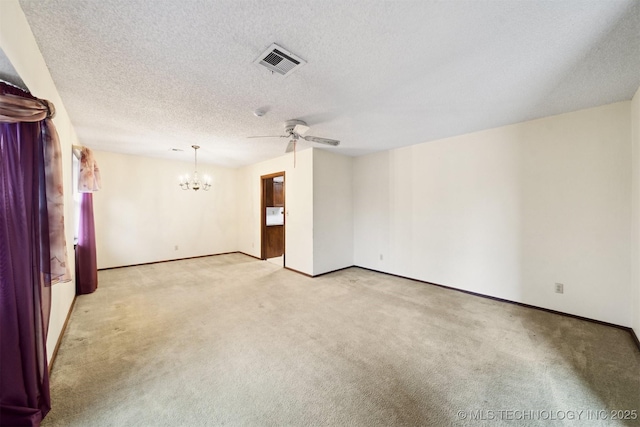 carpeted empty room with ceiling fan with notable chandelier and a textured ceiling