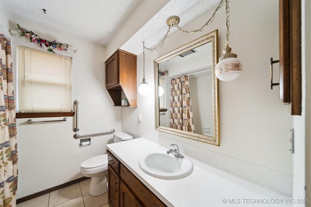 bathroom featuring vanity, toilet, tile patterned flooring, and a textured ceiling