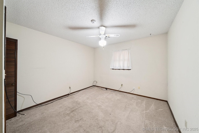 carpeted spare room with a textured ceiling and ceiling fan