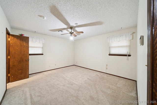 carpeted empty room with a textured ceiling and ceiling fan