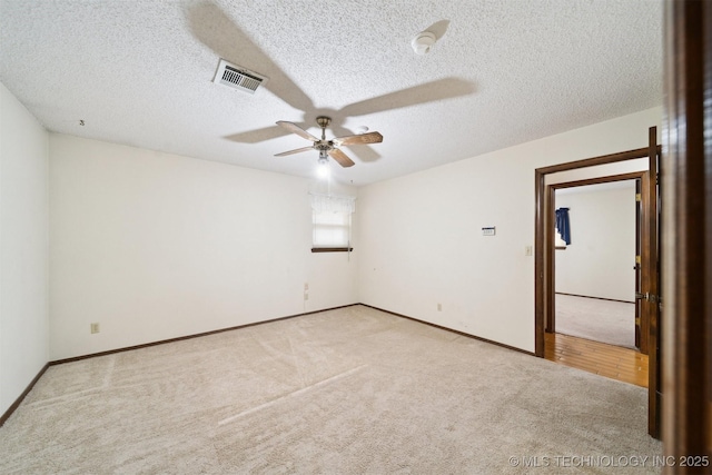 spare room with light carpet, a textured ceiling, and ceiling fan