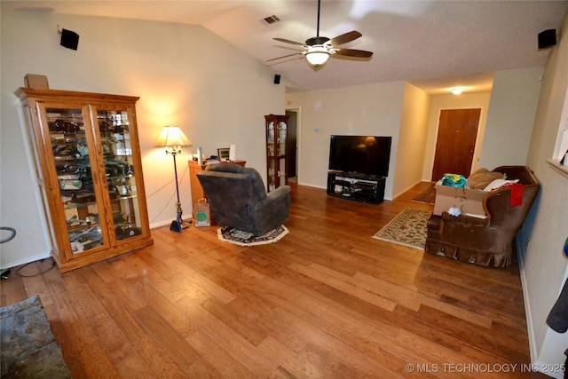 living room with wood-type flooring, ceiling fan, and vaulted ceiling