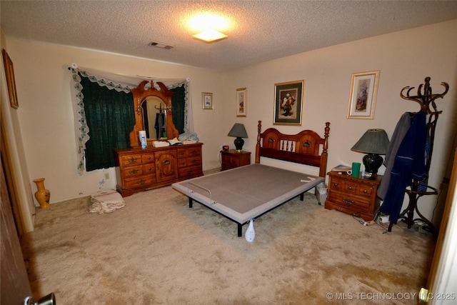 bedroom featuring carpet flooring and a textured ceiling