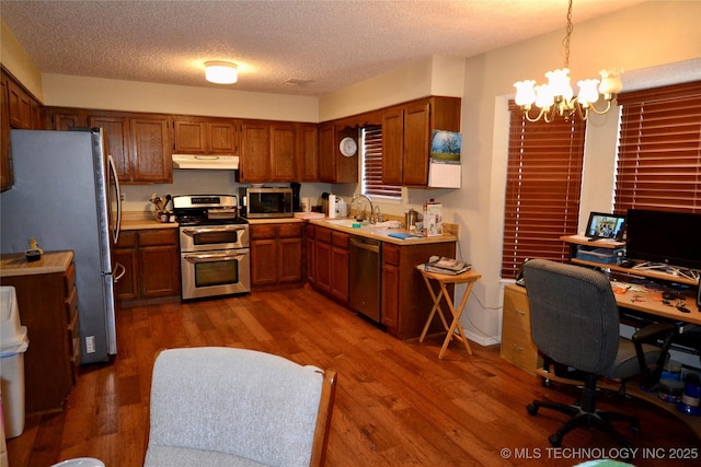 kitchen with pendant lighting, sink, dark hardwood / wood-style flooring, and appliances with stainless steel finishes